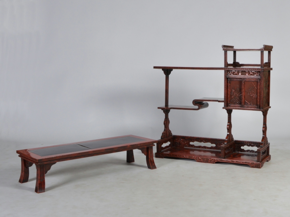 An early 20th century Chinese red lacquer display stand and a similar low table, the display stand