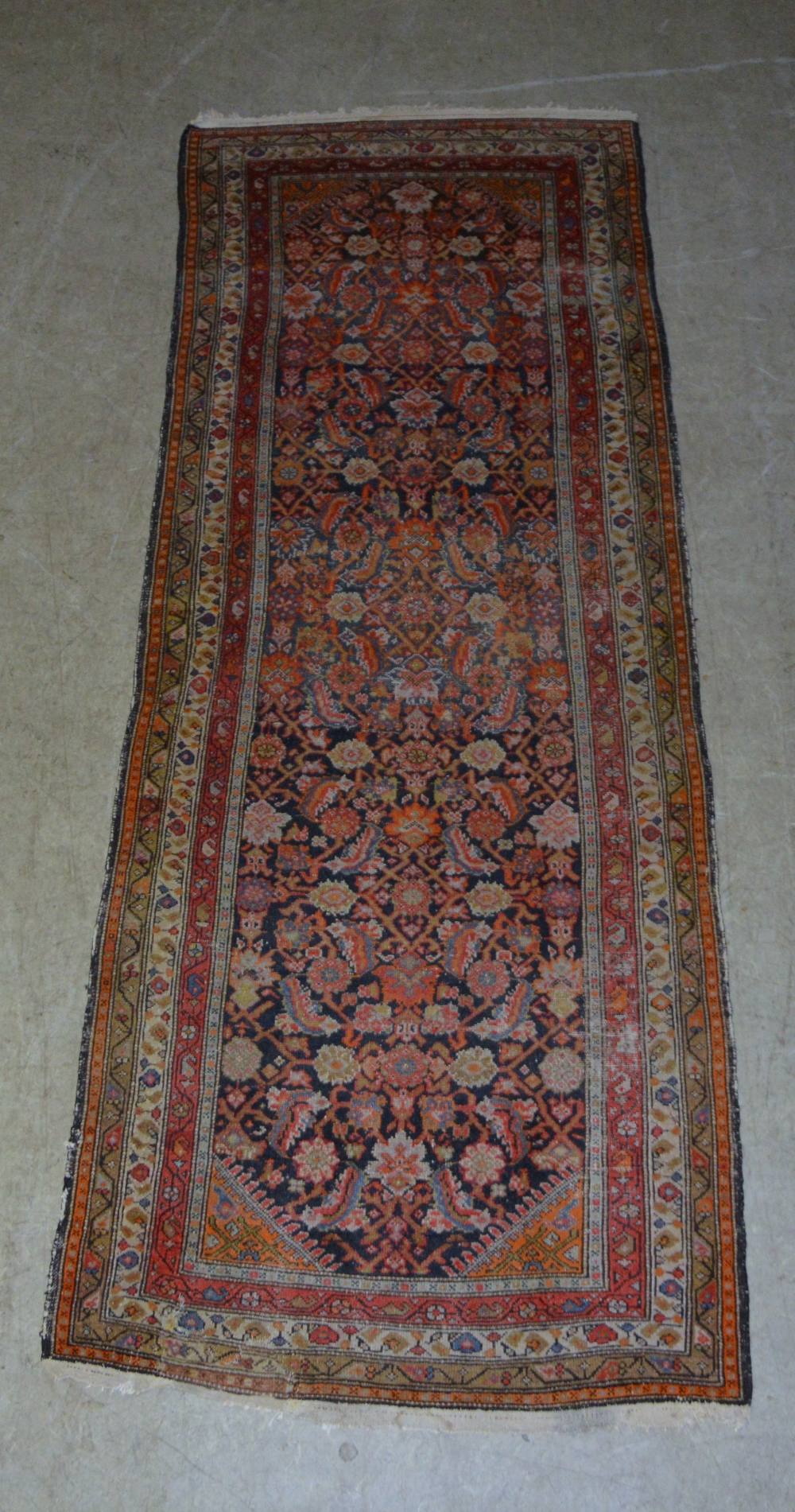 A Persian runner, probably Sarouk, the central blue ground field decorated with flower heads,