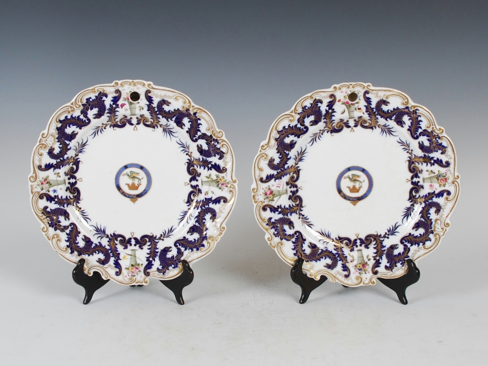 A pair of Chamberlains Worcester Armorial decorated warming plates, the Armorials inscribed `