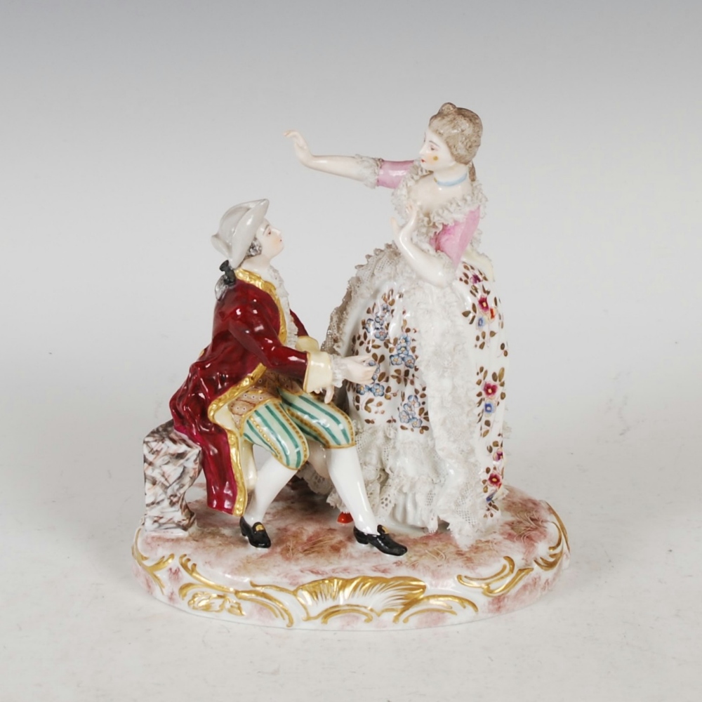A late 19th/ early 20th century Dresden figure group, modelled with a lady standing wearing 18th