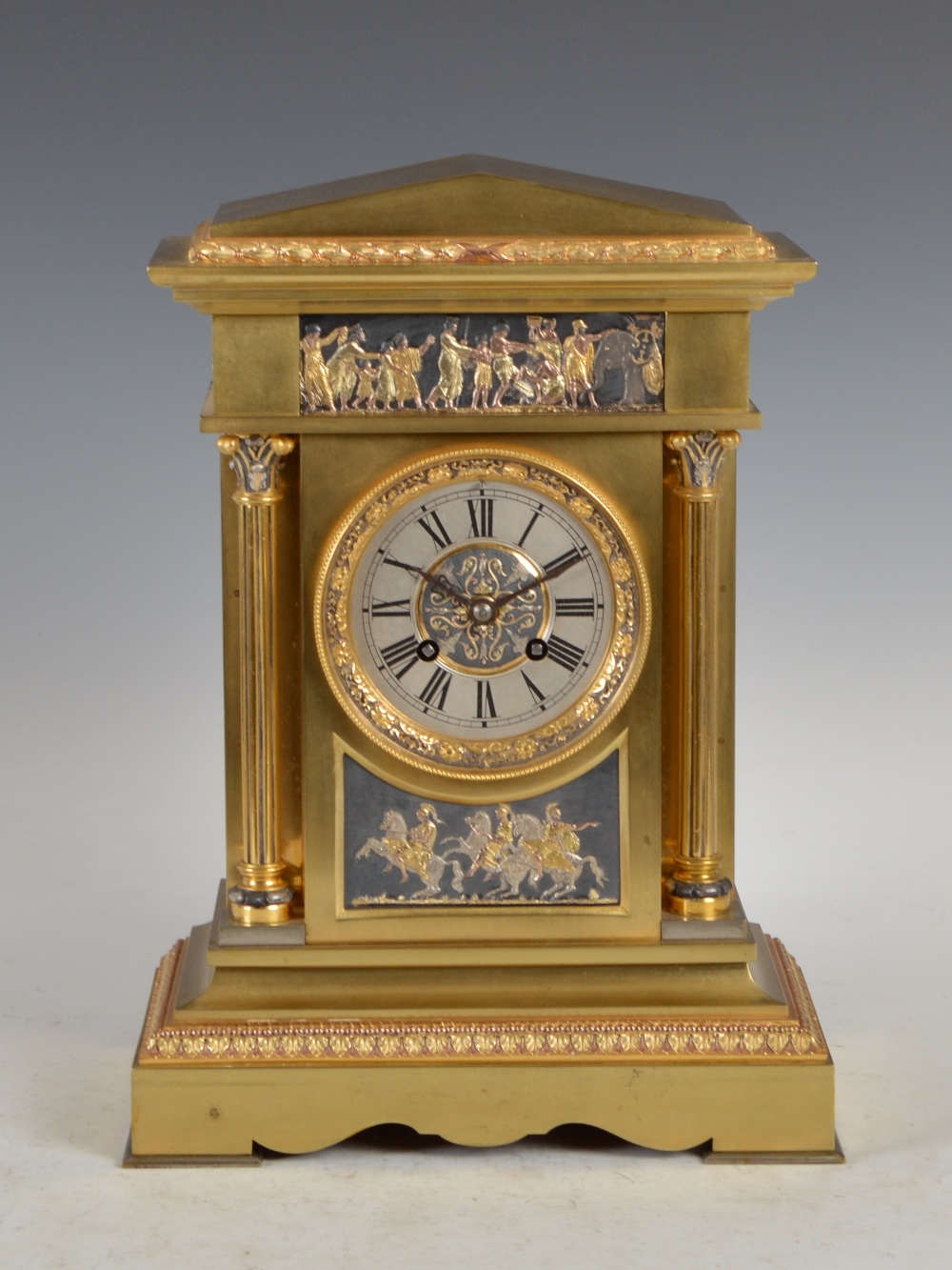 A late 19th/ ealry 20th century gilt metal mantle clock, the circular dial with Roman numerals and