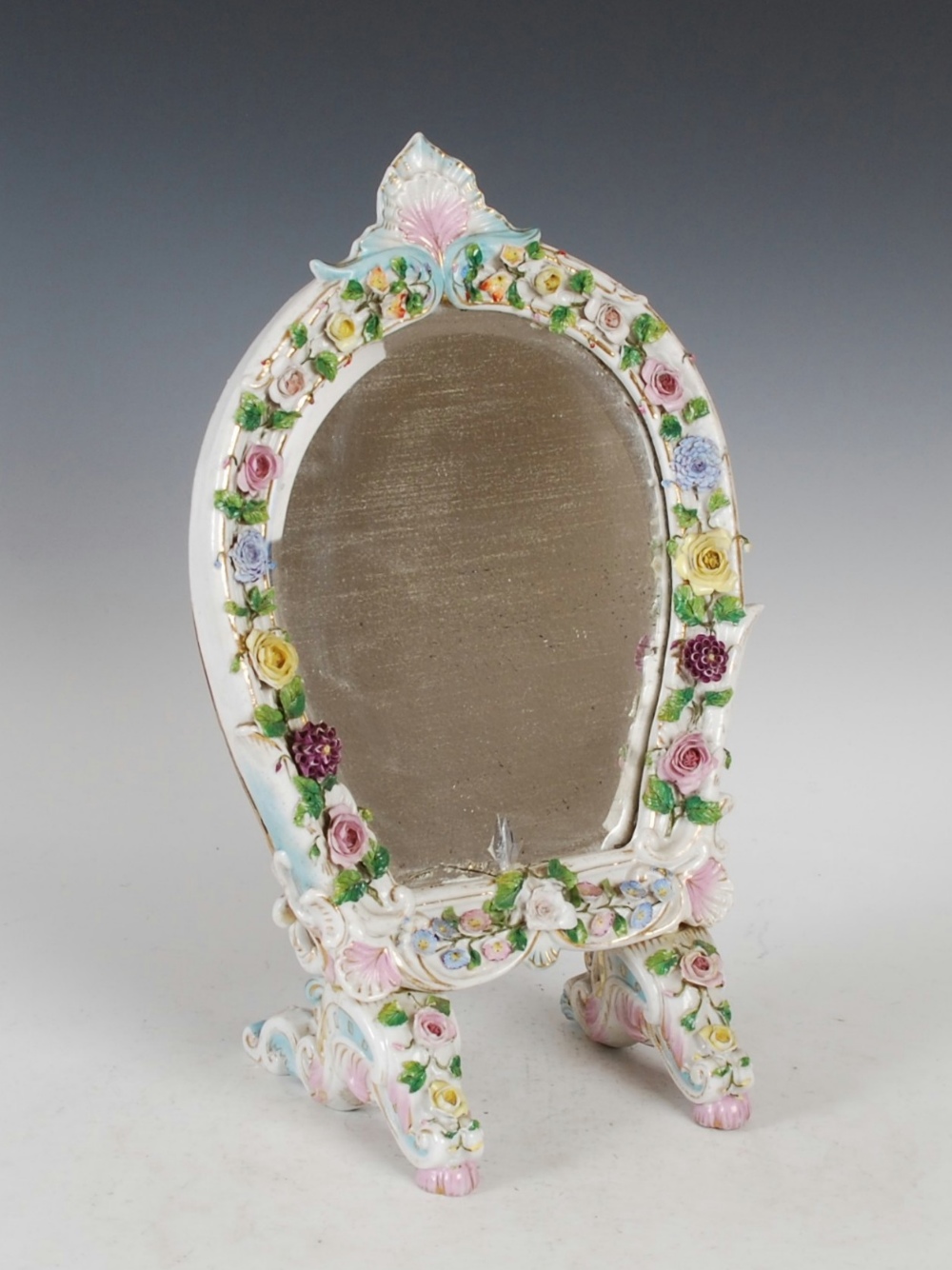 A Dresden porcelain dressing table mirror, the bevelled mirror plate within a flower encrusted