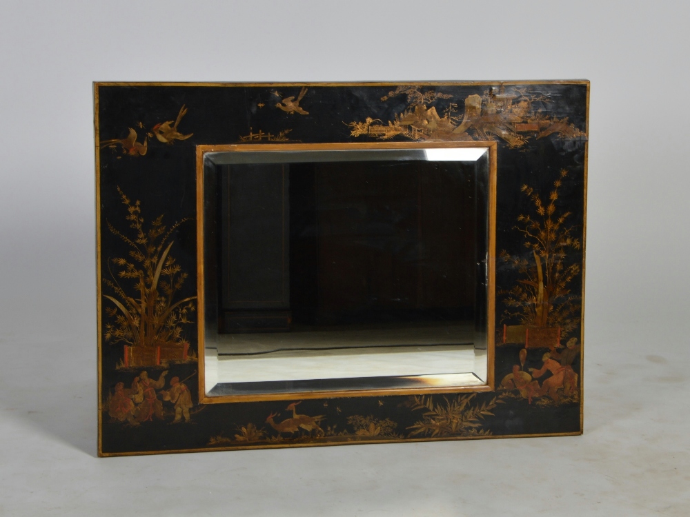 An early 20th century chinoiserie decorated lacquer wall mirror, the rectangular bevelled mirror