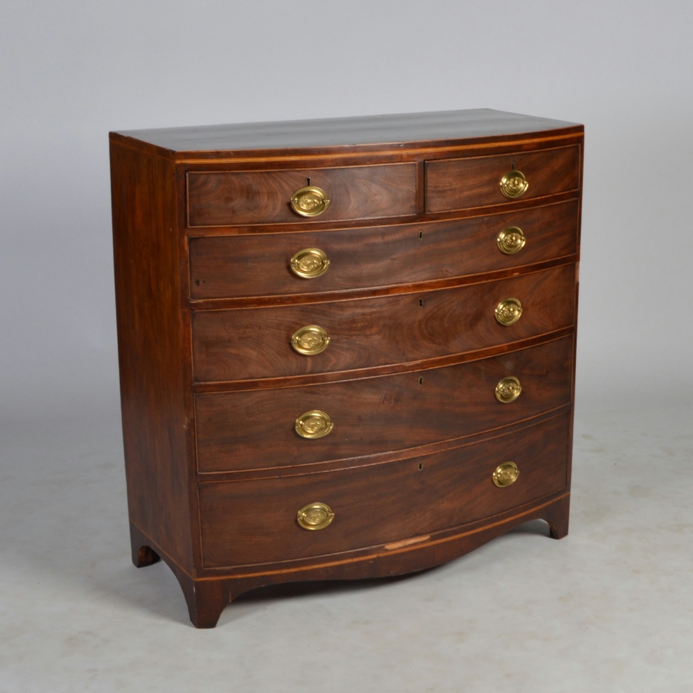 A George III mahogany and boxwood lined bow front chest, the shaped rectangular top above two