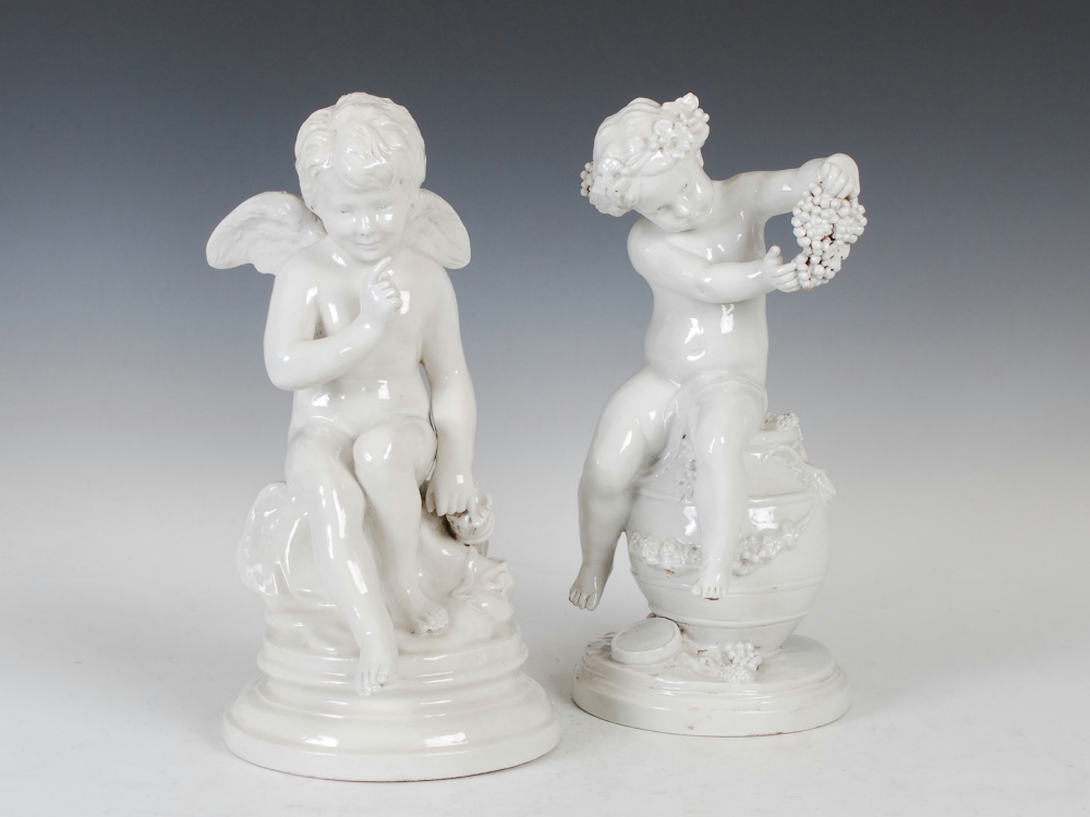 A pair of Naples porcelain blanc de chine figures of Cherub and Putti, the cherub figure modelled