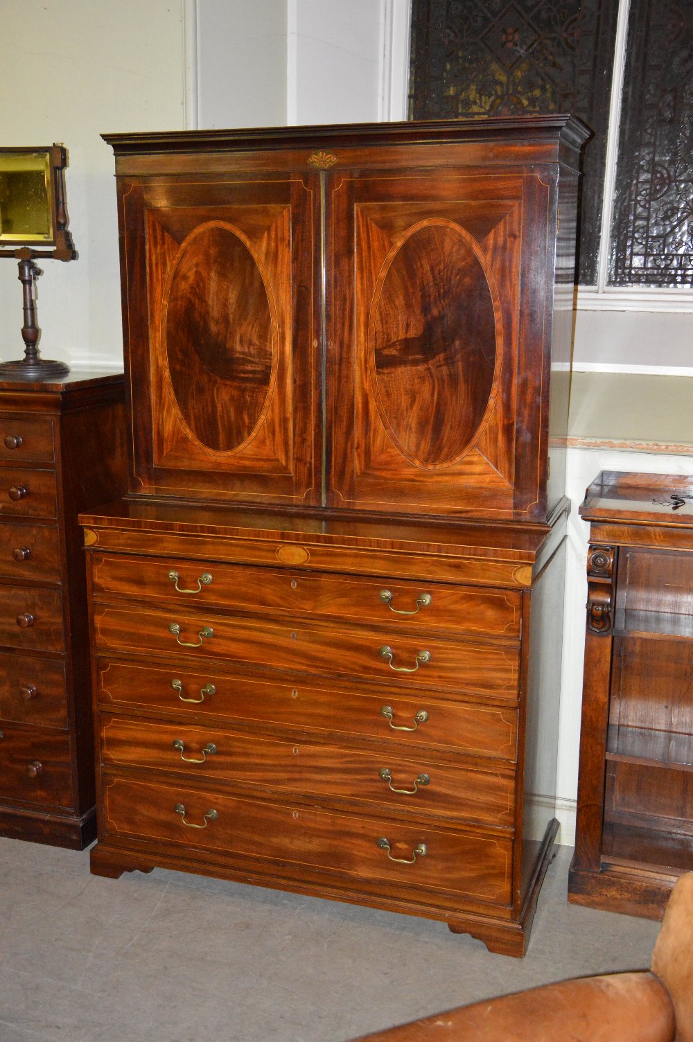 A George III mahogany and boxwood lined secretaire bookcase, the moulded cornice above a frieze