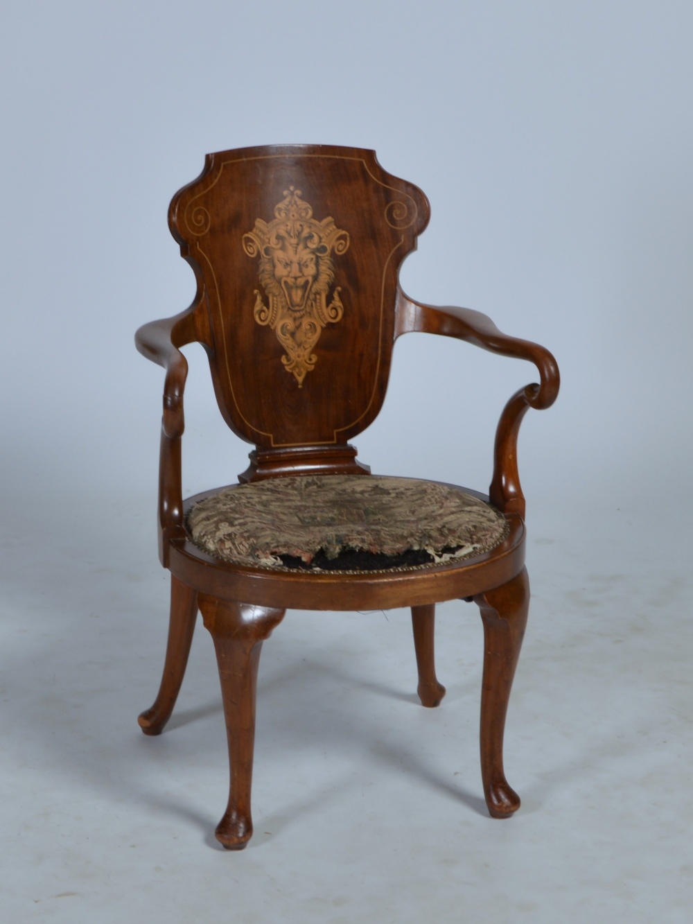 An Edwardian mahogany and marquetry armchair, the concave back inlaid with lion mask and scroll
