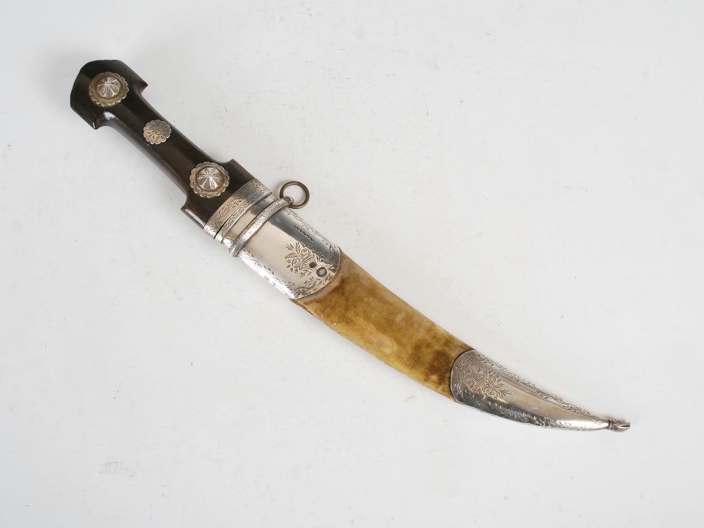 An Eastern white metal mounted hunting knife, the double edged blade with a carved horn handle,