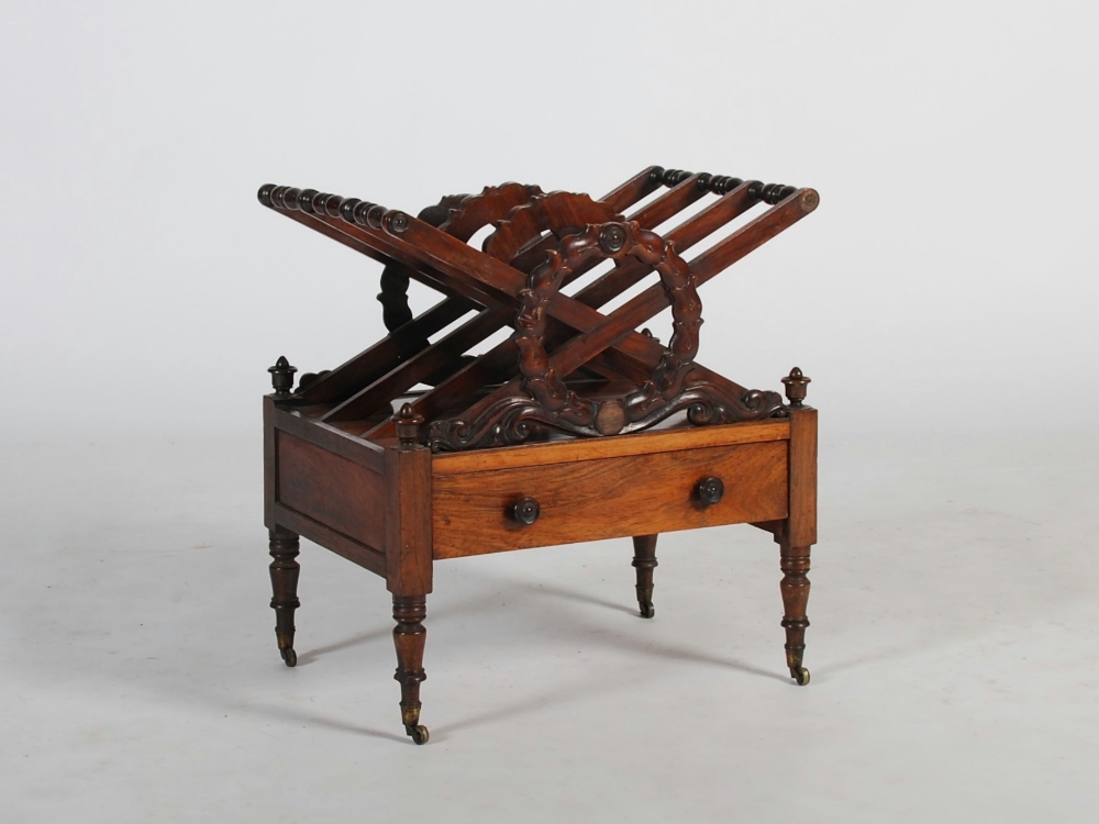 A 19th century rosewood Canterbury, with three divisions fronted by a laurel wreath above a single