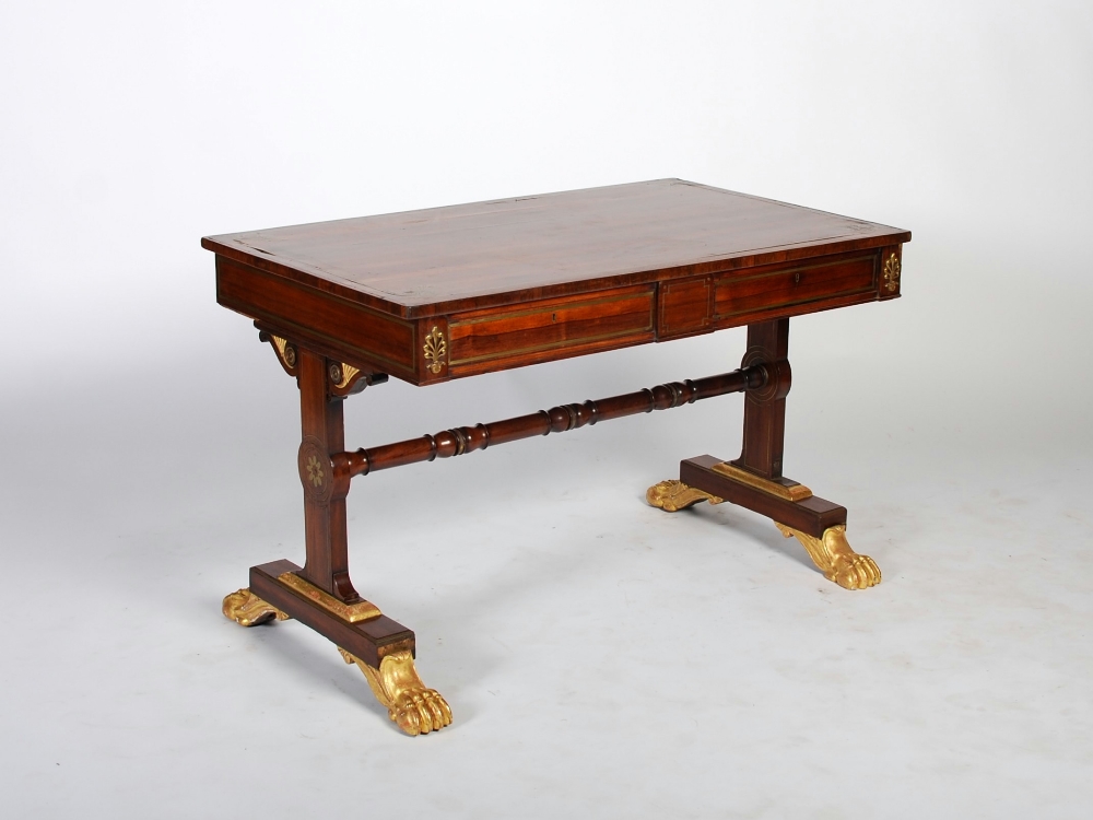 A 19th century Regency taste rosewood and brass inlaid library table, the rectangular top with brass