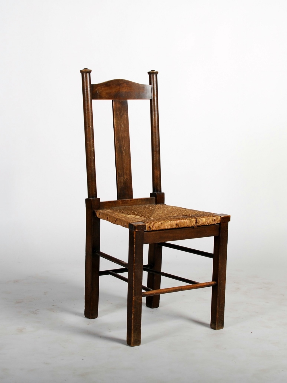 An Arts and Crafts stained beech side chair, the arched top rail and rectangular splat flanked by