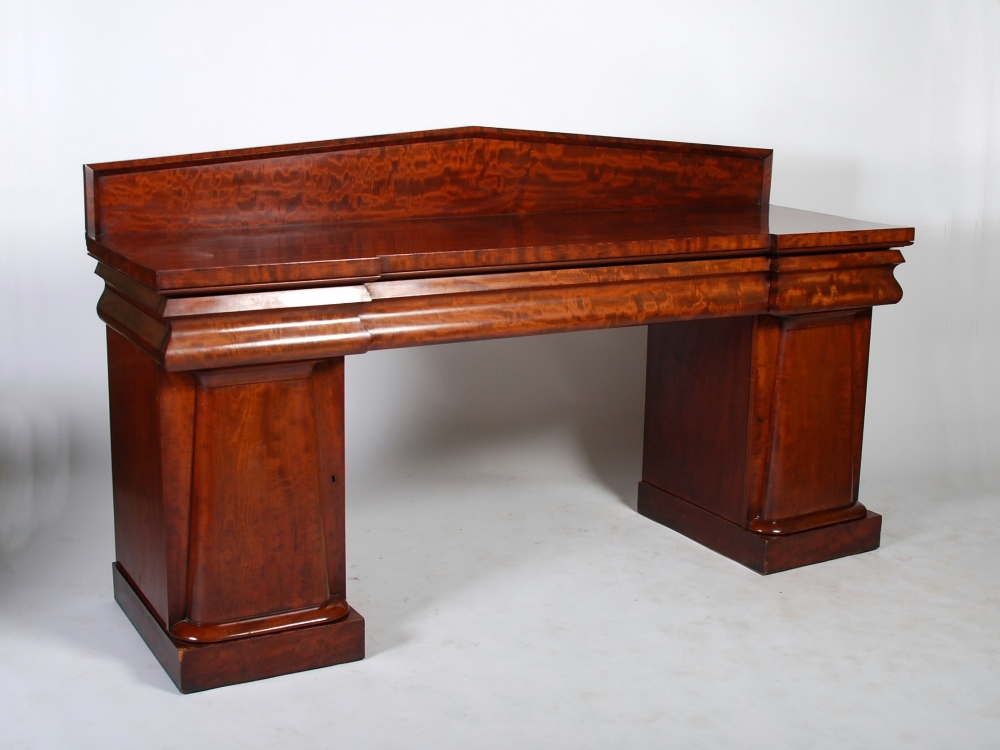 A Victorian mahogany inverted breakfront sideboard, the rectangular top with upright angular back,