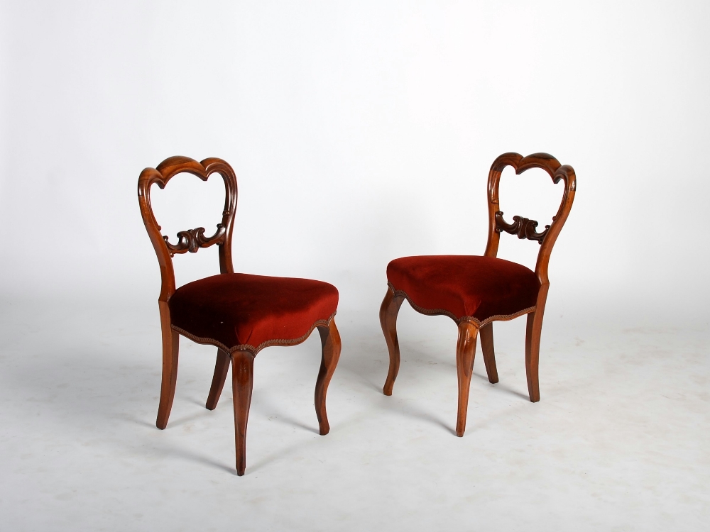 A set of six Victorian rosewood balloon back dining chairs, the shaped backs with scroll details,