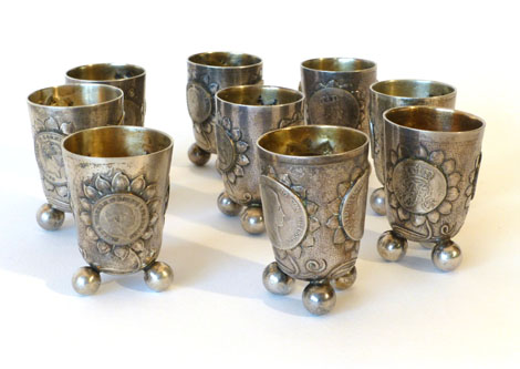 A set of nine metalwares licks, each set with three Prussian and other coins within a sunflower