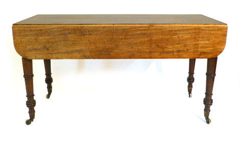 A Regency mahogany drop leaf supper table, the rectangular top with drop ends on ring turned
