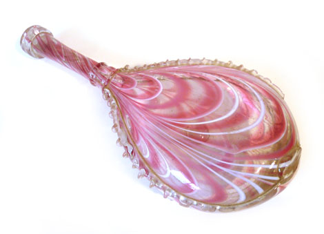 A Nailsea style glass flask decorated in pink and white, having nipped decoration to the body