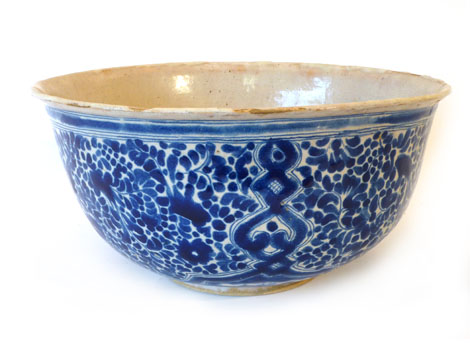 A tin glazed bowl of imposing proportions, the hemispherical body decorated with scrolls and