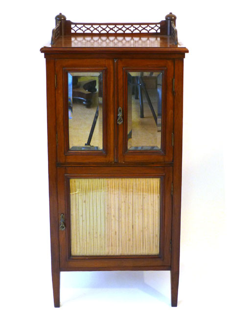 An Edwardian mahogany music Canterbury enclosed by three doors, two with bevelled mirror panels,