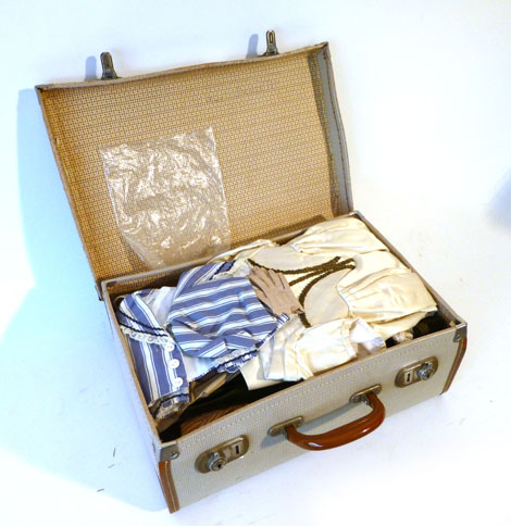 A suitcase containing a selection of Victorian and later dolls clothing