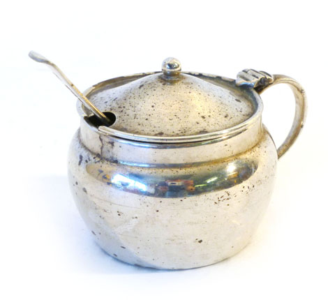 A George V silver mustard of squat circular form with scroll handle and blue glass liner together