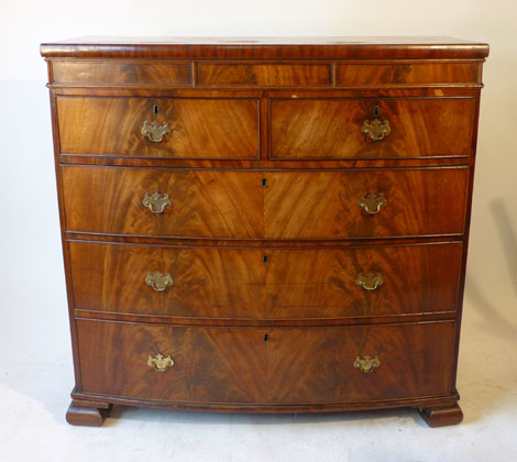 A George III mahogany and rosewood banded bow fronted chest of two short over three long graduated