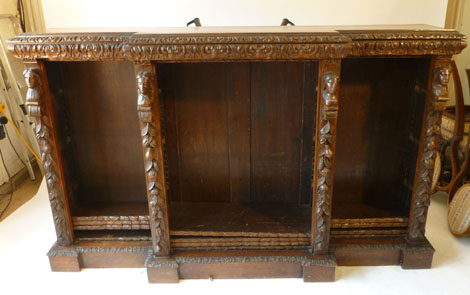 A Victorian carved oak breakfront bookcase with foliate border and carved uprights with fruit and