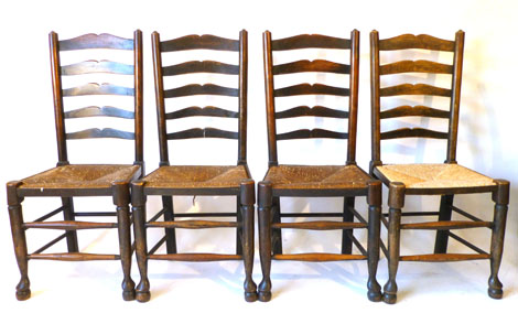 Set of four 19th century wavy ladder back chairs with rush seats on turned tapering legs with pad