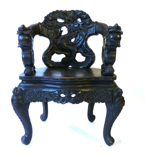 A Chinese ebonised open elbow chair, carved with dragon and cloud motifs over a serpentine seat with