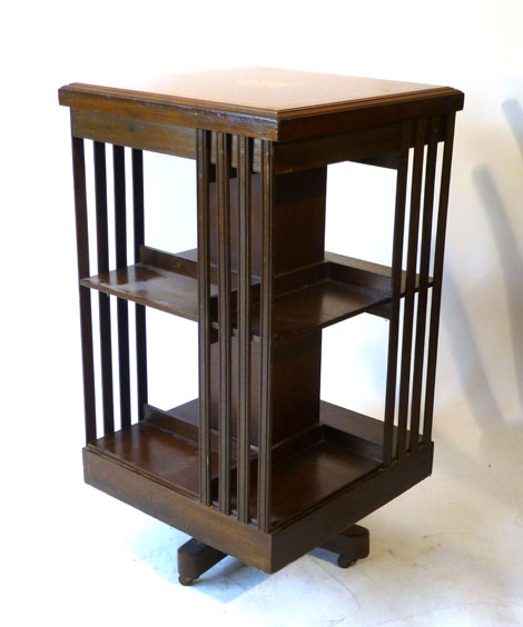 An Edwardian inlaid mahogany revolving bookcase, top with a fan motif and central square column with