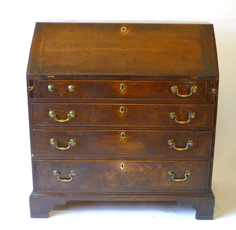 A George III oak bureau, the fall front revealing a fitted interior over a four long graduated