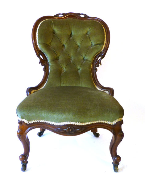 A Victorian framed spoon back nursing chair with pierced scroll motifs, button back upholstered in a