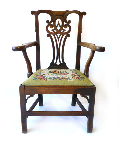 A George III mahogany open elbow chair with pierced scroll splats and tapestry drop in seat on