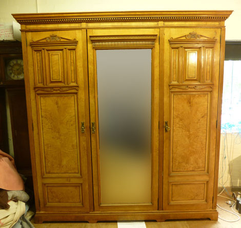 A Victorian satinwood triple wardrobe, the centre mirrored door flanked by a pair cupboard doors,