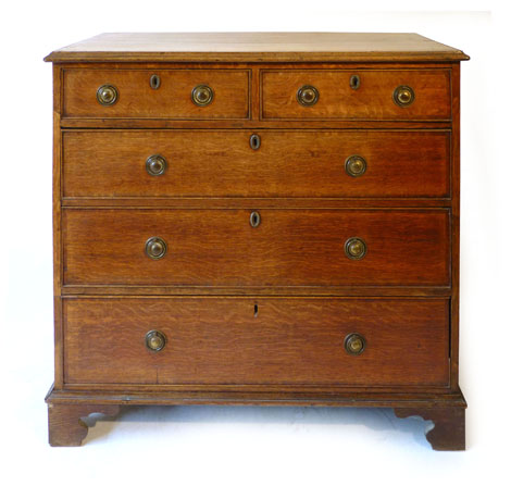 A George III oak mahogany crossbanded chest two short over three long drawers, with pressed brass