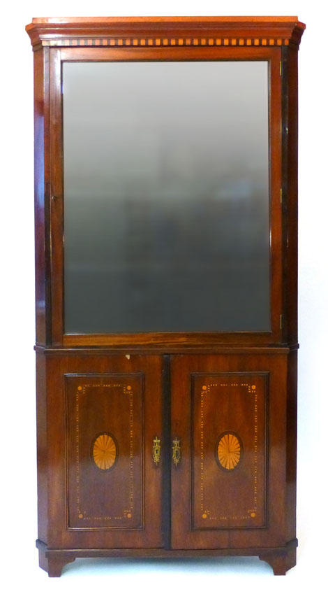 An Edwardian mahogany floor standing corner cupboard, the glazed upper section above a pair of