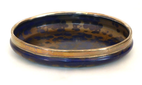A Royal Doulton Flambe pottery dish of oval form decorated with cherry blossoms on a blue ground