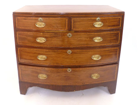 A George III mahogany bow fronted chest of two short over three long drawers, cross banded and