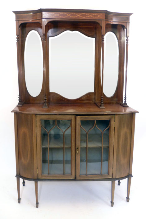 An Edwardian mahogany mirror back sideboard on a breakfront base with a pair of glazed cupboard