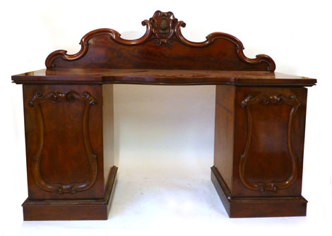 A Victorian mahogany serpentine fronted buffet sideboard, the gallery with scroll and pineapple