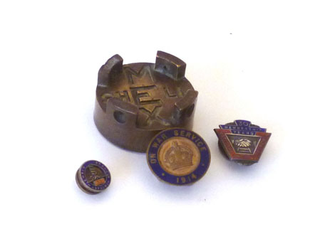 A Shell brass petrol cap together with three enamelled badges - National Union of Railway Men, N War