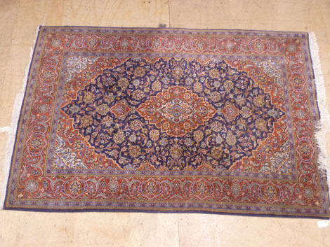 A fine Isfahan rug with central medallion in a surround of flowers within multi borders in red,