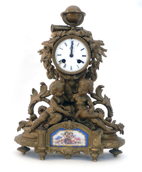 A French gilt spelter mantel clock with Roman dial enclosing an eight day movement with a pair of