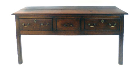 A George III oak dresser base, the plank top above three drawers on two champhered square legs, w161
