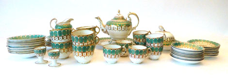 A Victorian part tea and dinner service decorated in green and gilt lobed decoration on a cream