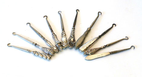 A collection of ten silver handled button hooks of various styles including bright cut, hammered and