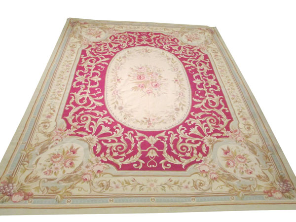 NEEDLEPOINT CARPET, 357cm x 279cm, the claret coloured field of ton sur ton decoration around a