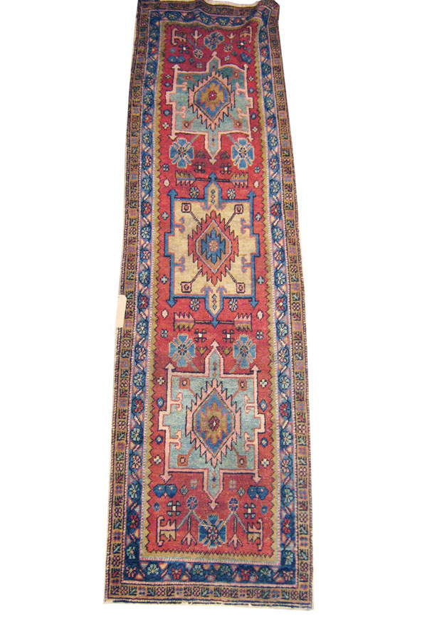 ANTIQUE HERIZ RUNNER, Persia circa 1880, 280cm x 76cm, row of geometric medallions on terracotta