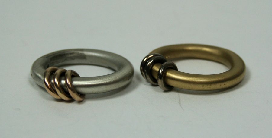 A pair of 18ct gold rings of plain design, one white gold with three yellow gold feature rings