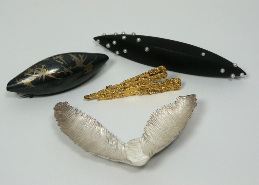 A collection of brooches to include a white metal brooch by Judy McCraig in original hand crafted