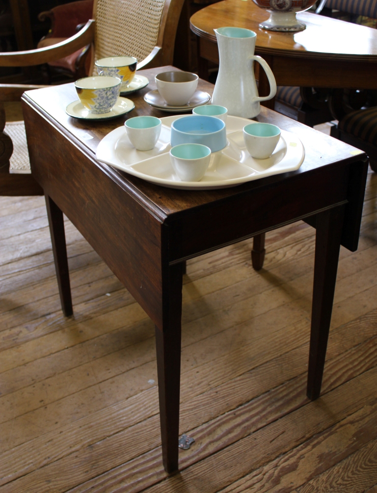 A Georgian mahogany oblong shaped drop leaf table with plain frieze raised on square tapering